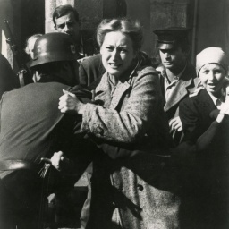 Standfoto aus der Serie "Holocaust", auf dem Meryl Streep von einem Soldaten mit Stahlhelm festgehalten, während sie versucht, sich mit schmerz verzerrtem Gesicht loszureißen.