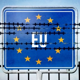 Symbolbild: Stacheldrahtzaun vor einem Schild mit der Aufschift "EU" und dem EU-Sternenkranz.