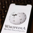 Das Logo der Online-Enzyklopädie Wikipedia ist auf einem Mobiltelefon zu sehen.
