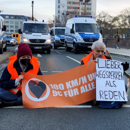 Sechs Aktivisten der Gruppe "Letzte Generation" haben sich auf einer mehrspurigen Straße am Hauptbahnhof in Mainz mit einer Hand auf dem Asphalt festgeklebt.