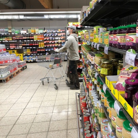 Blick in einen Supermarkt mit vollen Regalen. 