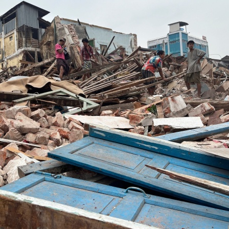 Menschen räumen Trümmer nach dem Erdbeben in Myanmar weg.