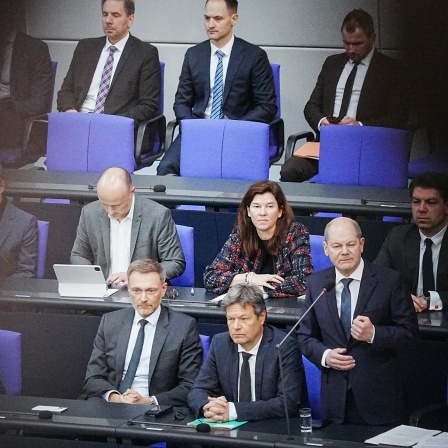 Bundeskanzler Olaf Scholz (SPD, 2.v.r) spricht im Bundestag bei der Befragung der Bundesregierung neben Christian Lindner (FDP, l), Bundesminister der Finanzen, und Robert Habeck (Bündnis 90/Die Grünen, M), Bundesminister für Wirtschaft und Klimaschutz,