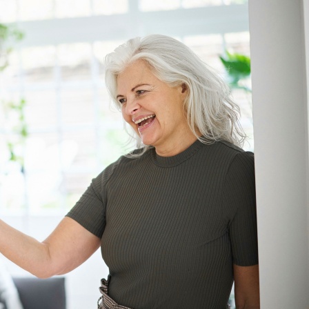 Frau mit grauen Haaren telefoniert mit dem Smartphone