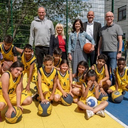 Beim Projekt "Sport vernetzt" von Alba Berlin zeigen sich Kinder der Basketballgruppe und Organisatoren in Berlin.