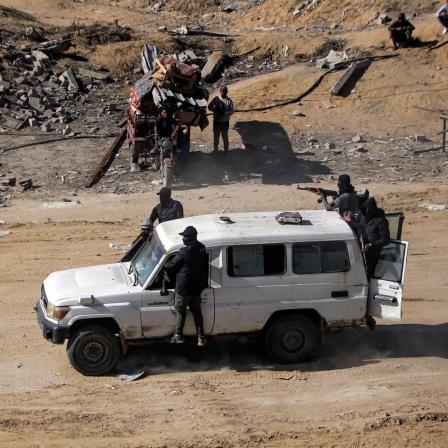 Kämpfer der Terrororganisation Hamas fahren bewaffnet in einem Jeep in Rafah im Gazastreifen (Israel).