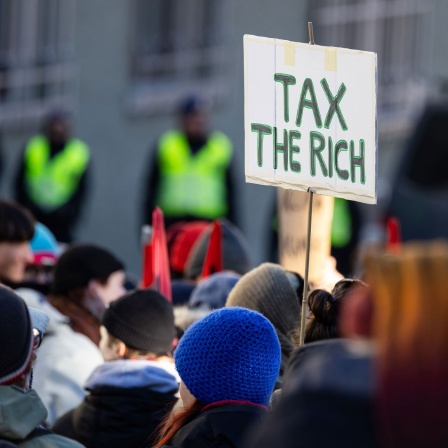 Bei einer Demonstration für Klimagerechtigkeit ist ein Schild mit der Aufschrift "Tax the Rich" zu sehen (Bild: dpa / Hannes P. Albert)