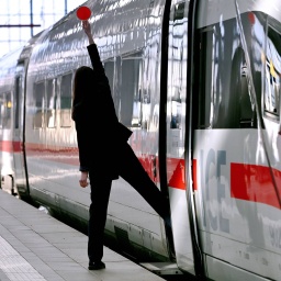Ein ICE Zug steht zur Abfahrt bereit. Zugbegleiterin signalisiert dem Lokührer mit roter Kelle, dass der Zug zur Abfahrt bereit ist. (Bild: picture alliance / SvenSimon | Frank Hoermann)