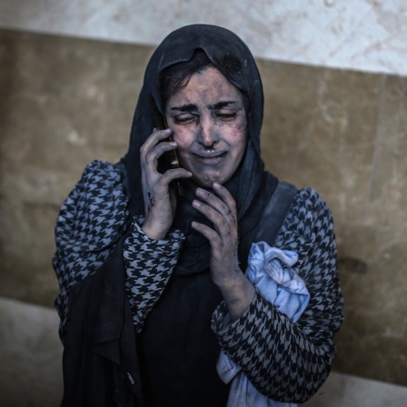 Eine verwundete Frau telefoniert im Nasser-Krankenhaus nach einem Luftangriff.