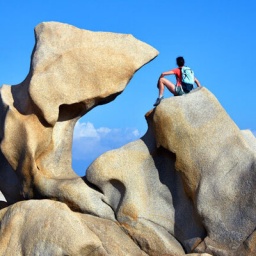 junge Wanderin macht Pause an charakteristischen Kuestenfelsen bei Campomoro, Frankreich, Korsika