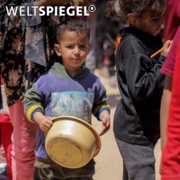 Palästinensisches Kind mit Schüssel in der Hand wartet in einer Essensschlange in Gaza im April