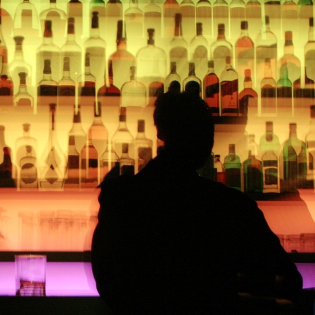 Ein Mann sitzt an der Bar.