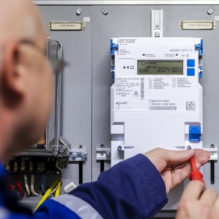 Ein Monteur installiert einen Smart Meter-Stromzähler in einem Haus