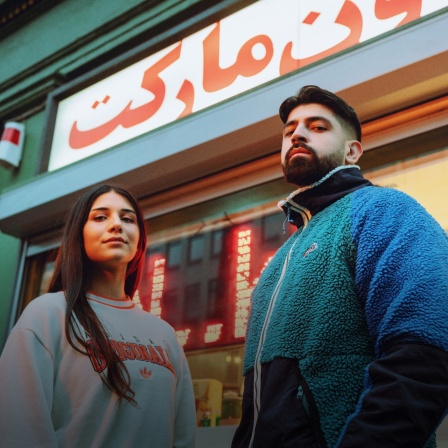 Meltem und Yousuf von Chai Society stehen vor einem Kiosk.