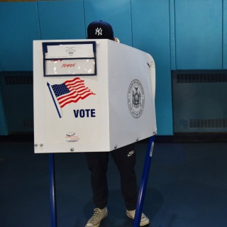Das Beitragsbild des Dok5 "Die Dirty Tricks der Demokratie" zeigt zwei Wähler hinter Wahlkabinen mit der Aufrischt Vote in New York City, 2020.