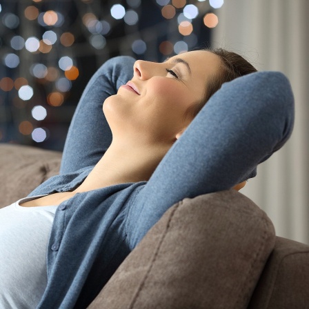 Frau sitzt entspannt auf einem Sofa