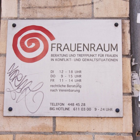 Schild an einer Hauswand mit der Aufschrift &#034;Frauenraum&#034;: Beratung und Treffpunkt für Frauen in Konflikt- und Gewaltsituationen in Berlin