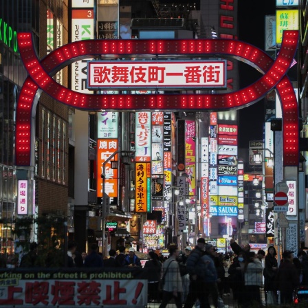 Das Foto zeigt den rot beleuchteten Kabukicho-Ichibangai-Bogen in Kabukicho, Japans größtem Ausgehviertel, im Tokioter Bezirk Shinjuku. 