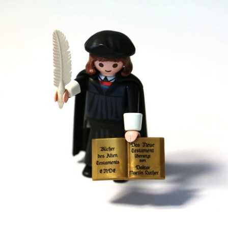 Playmobilfigur von Martin Luther mit Feder in der Hand