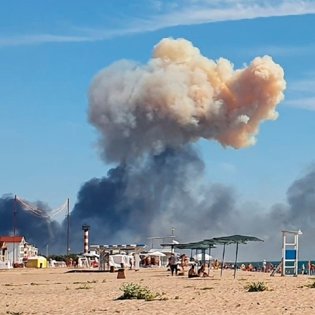 Am Strand von Saky auf der ukrainischen Halbinsel Krim ist Rauch nach einer Explosion am Horizont zu sehen.