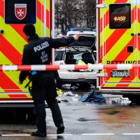 13.02.2025, Bayern, München: Rettungskräfte stehen in der Nähe des Einsatzortes. In der Münchner Innenstadt ist ein Fahrzeug in eine Menschengruppe gefahren. 