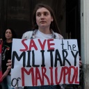 Eine Frau hält ein Schild in der Hand auf dem die Worte "Save the military of Mariupol" geschrieben sind