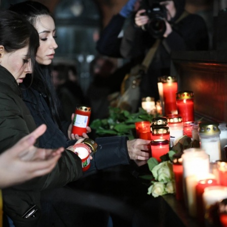 Terroranschlag in Hanau 2020: Trauerfeier auf dem Marktplatz. Im Bild l-r: Kerzen, Blumen werden niedergelegt. 