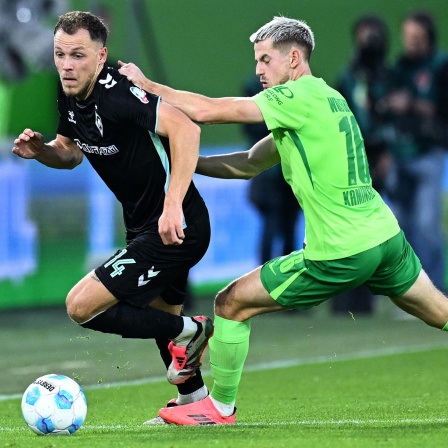 Senne Lynen von Werder Bremen im Zweikampf mit Jakub Kaminski vom VfL Wolfsburg