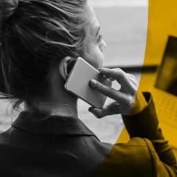 ARD Radiofeature Beitragsbild "Abgehört - Doku über das Geschäft mit Sprach-KI" zeigt eine Frau mit Smartphone an einem Laptop sitzend. 