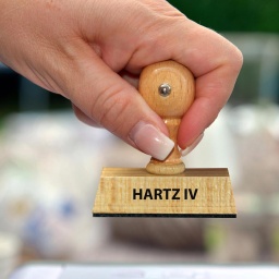 Hand mit Stempel und der Aufschrift: Hartz IV