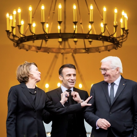 Frank-Walter Steinmeier (r-l), Emmanuel Macron und Elke Büdenbender, verlassen das Schloss Bellevue.