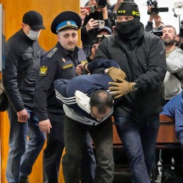 Ein Tatverdächtiger des Terroranschlags auf die Konzerthalle Crocus City Hall in Moskau wird von Polizisten und FSB-Beamten im Basmanny-Bezirksgericht eskortiert.