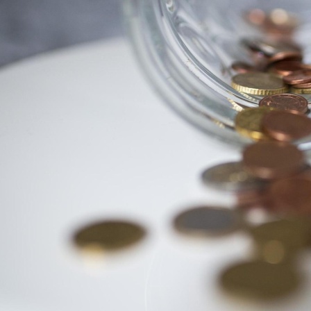Geld in Form von Münzen liegt auf einer Ablagefläche