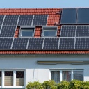 Ein Wohnhaus mit Solarzellen auf dem Dach.