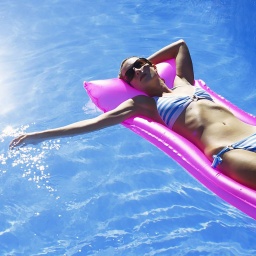 Frau auf einer Luftmatratze in einem Swimming Pool