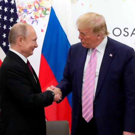 Russlands Staatschef Putin und US-Präsident Trump schütteln die Hand