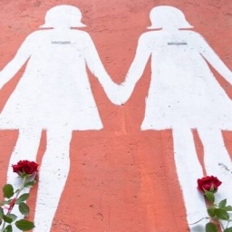 Silhouetten von Frauen aufgemalt an einer Häuserwand zusammen mit roten Rosen, in Gedenken an die getötete Italienerin Giulia Cecchettin