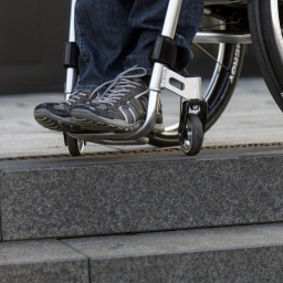 Rollstuhl steht am oberen Rand einer Treppe
