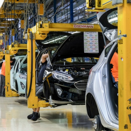 In der Produktionshalle der Endmontage fahren die aufgehängten Karosserien des Ford Fiesta im Schritttempo von einem Montagepunkt zum nächsten.