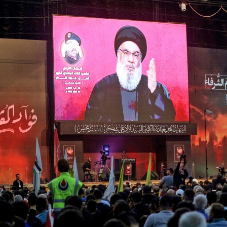 Hisbollah-Anhänger verfolgen ein Rede von Milizchef Hassan Nasrallah, die auf einem Bildschirm zu sehen ist.