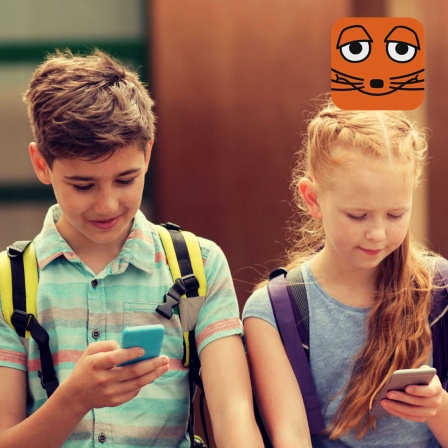 4 Kinder sitzen nebeneinander und schauen auf ihre Handys. Sie sind alle versunken und fasziniert von den Inhalten auf ihrem Smartphone. 