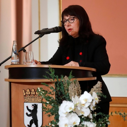 Petra Rosenberg steht an einem Pult der Stadt Berlin am Mikrofon