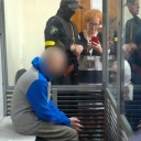 Ein russischer Soldat (verpixelt) sitzt in einer Glaskabine während einer Gerichtsverhandlung in Kiew.