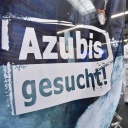 «Azubis gesucht» steht auf einem Banner am Stand einer Firma.