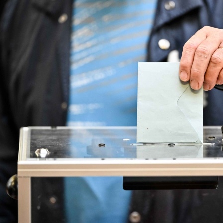Ein Wähler wirft seinen Wahlzettel in eine Box.