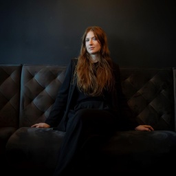 Sarah Swantje Fischer sitzt auf einem großen Sofa.