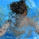 Ein Kind taucht im Swimmingpool.