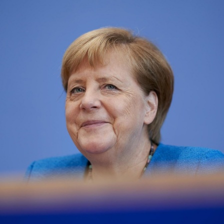 Bundeskanzlerin Angela Merkel vor einem blauen Hintergrund.