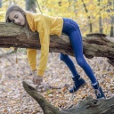Ein Mädchen liegt auf einem Baum.