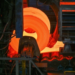 Glühender Flachstahl wird zu einem Coil im Warmwalzwerk der ArcelorMittal Eisenhüttenstadt GmbH aufgewickelt. 